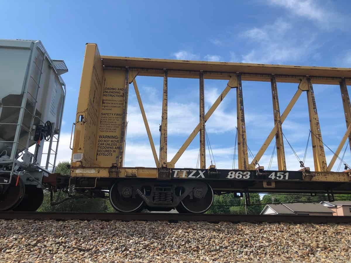 A photograph of a centerbeam car on a railroad track.