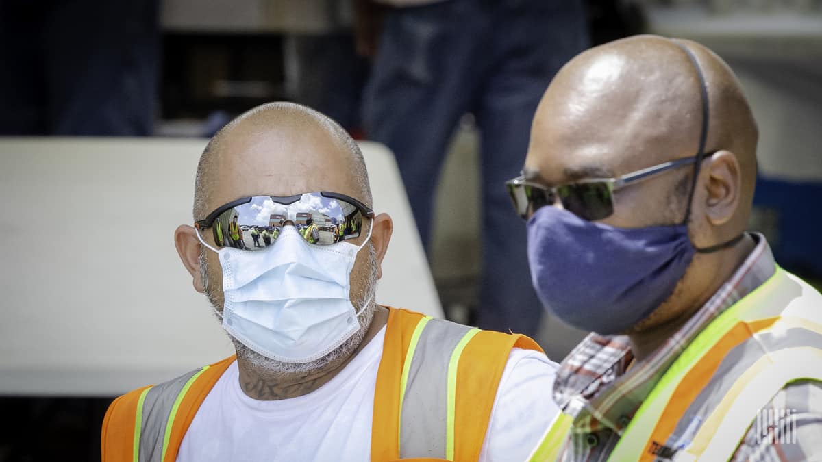 Workers wearing sun glasses and face masks.