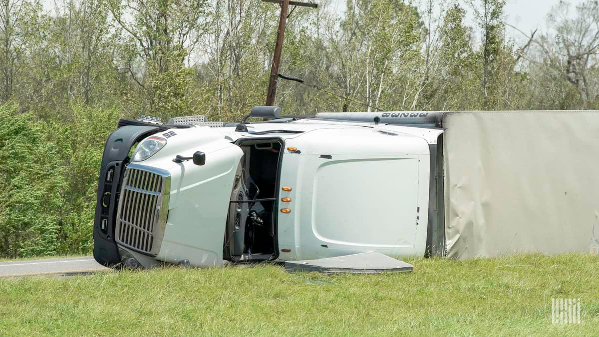 Tractor-trailer flipped on side of a highway.