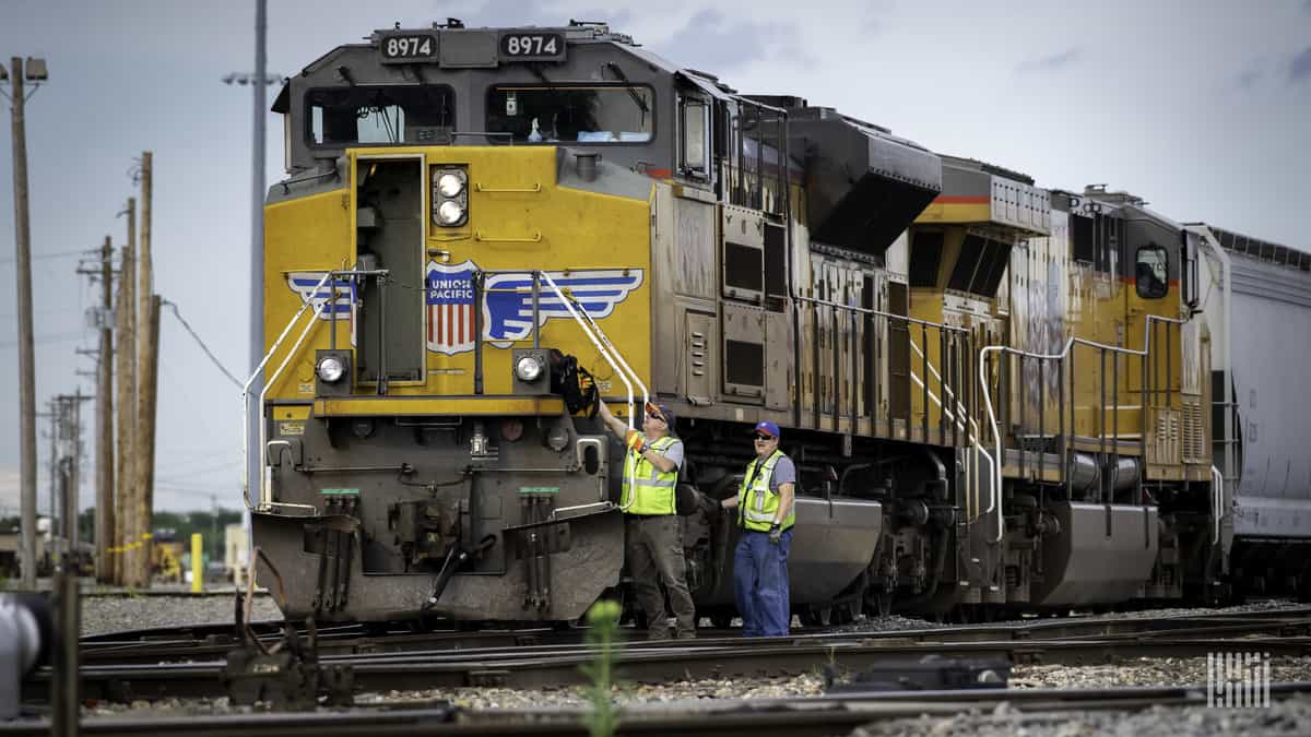 A photograph of two people in front of a Union Pacific locomotive.