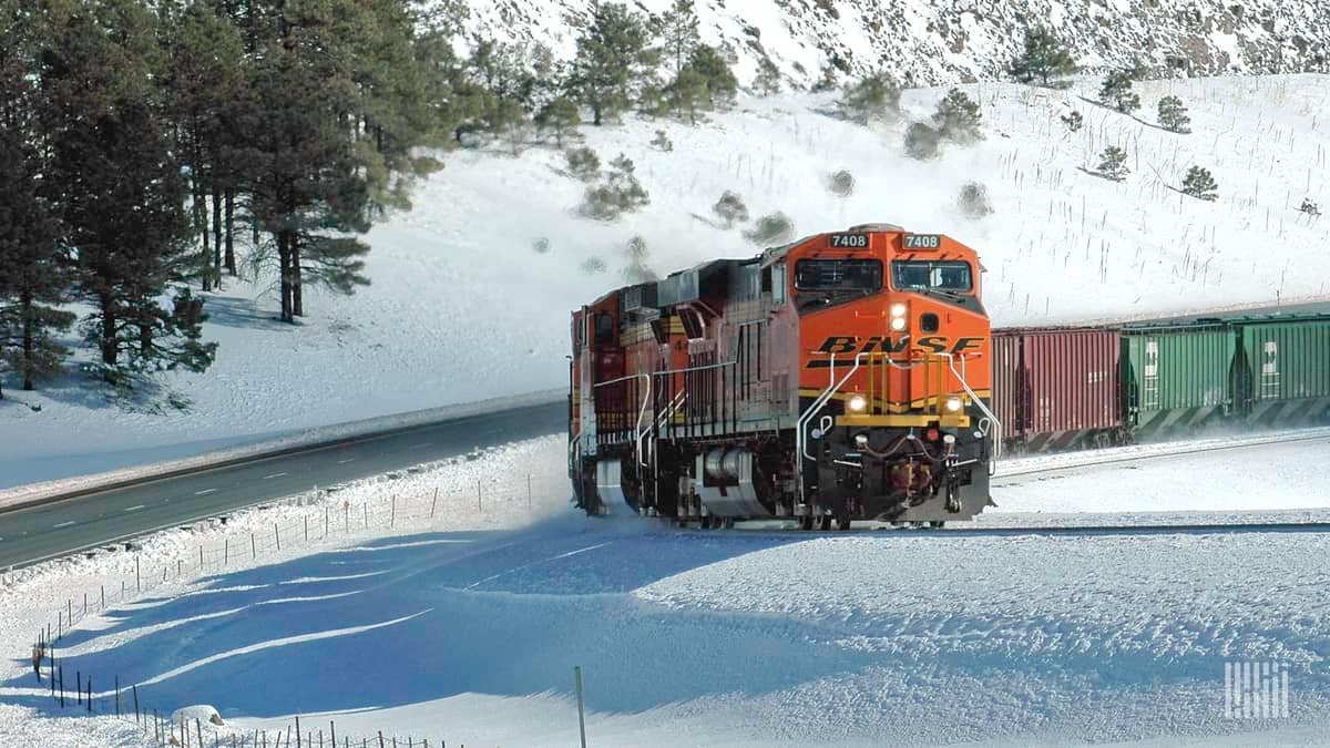 A photograph of a BNSF train traveling through a snowy field.