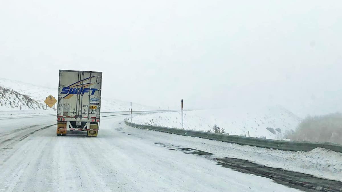 Tractor-trailer on a snowy California highway.