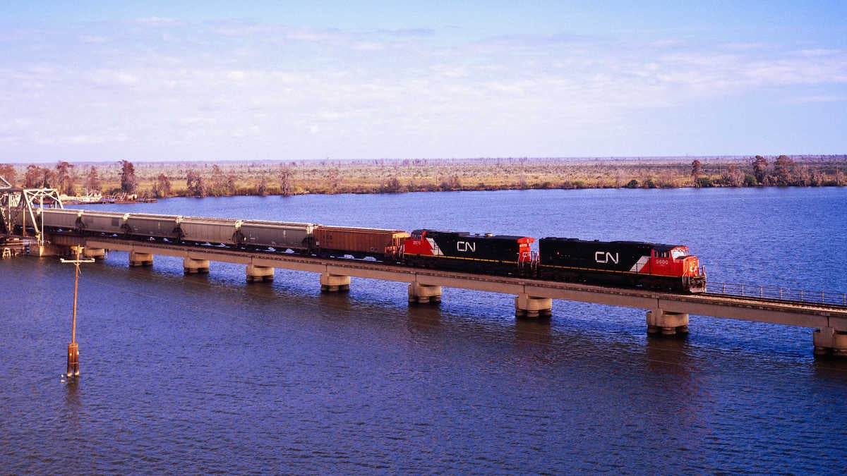 A photograph of a freight train crossing a long bridge.