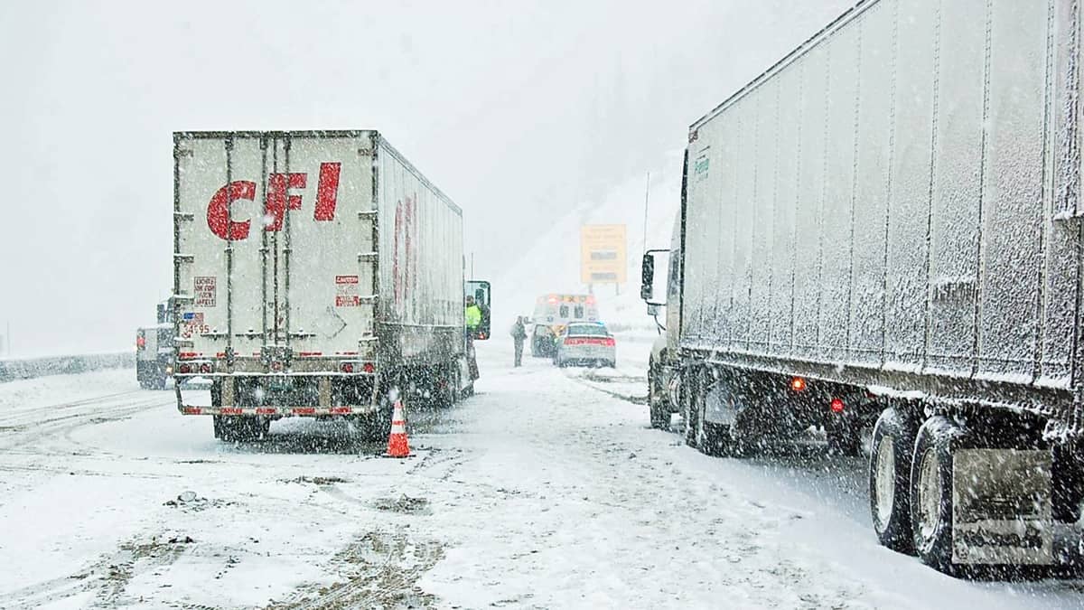 Tractor-trailers on snowy Colorado highway.