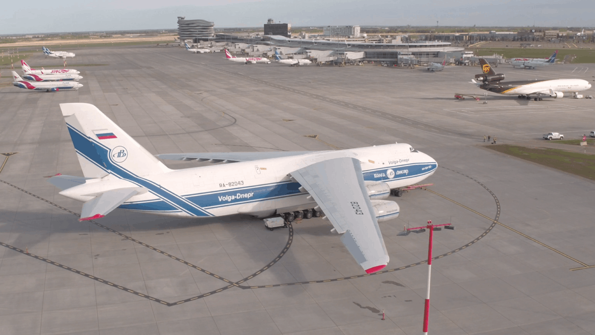 Aerial view of a big white cargo jet sitting on apron at airport.