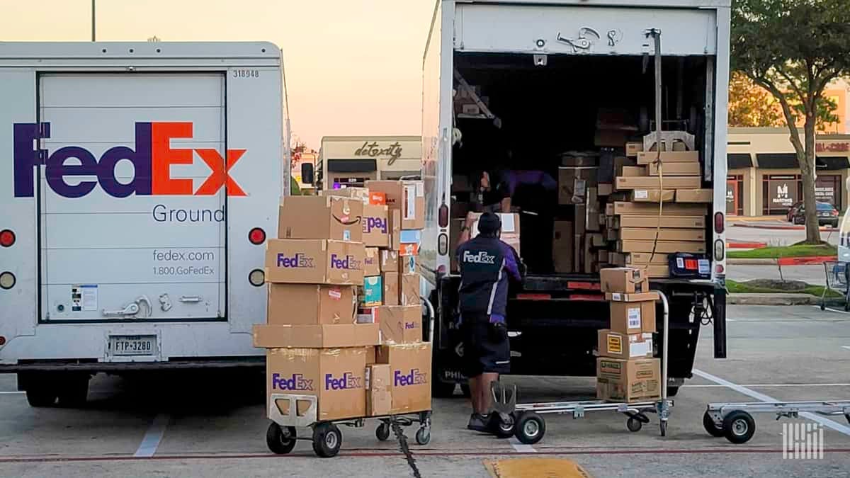 A FedEx driver unloads a parcel van.