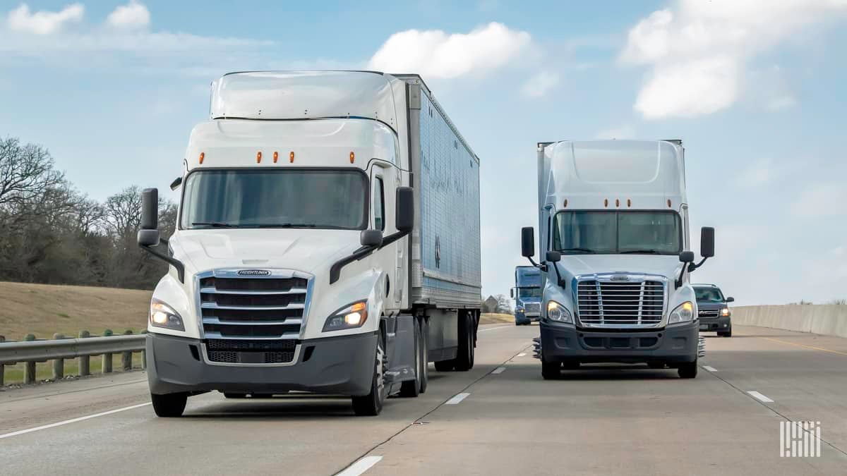 Two white trucks sharing the highway