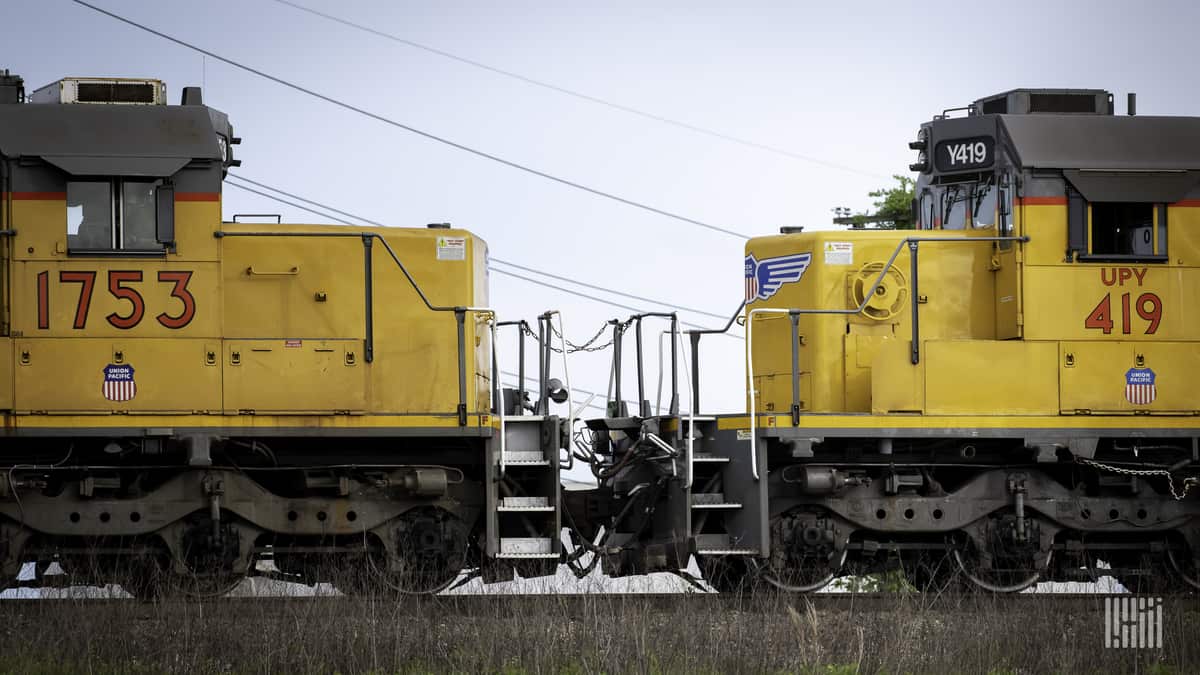 A photograph of two Union Pacific locomotives in a rail yard.