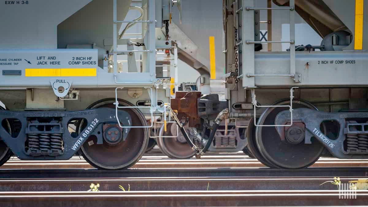 A photograph of two railcars connected to each other and parked in a rail yard.