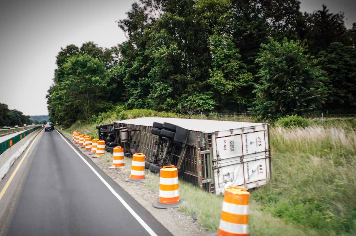 Tractor-trailer flipped on side of a highway.