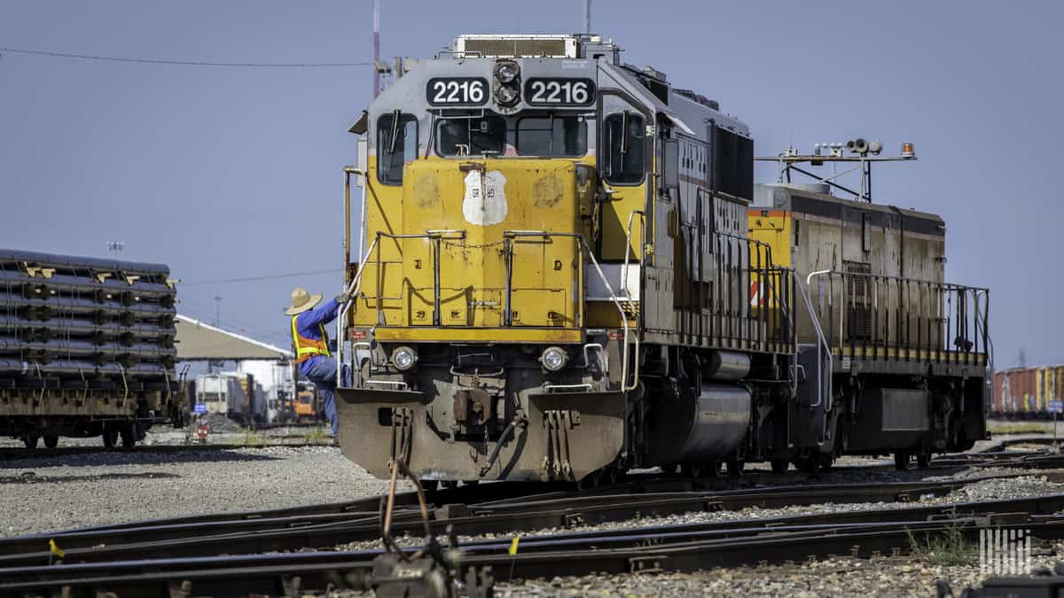 A photograph of a man standing in front of a Union Pacific locomotive.