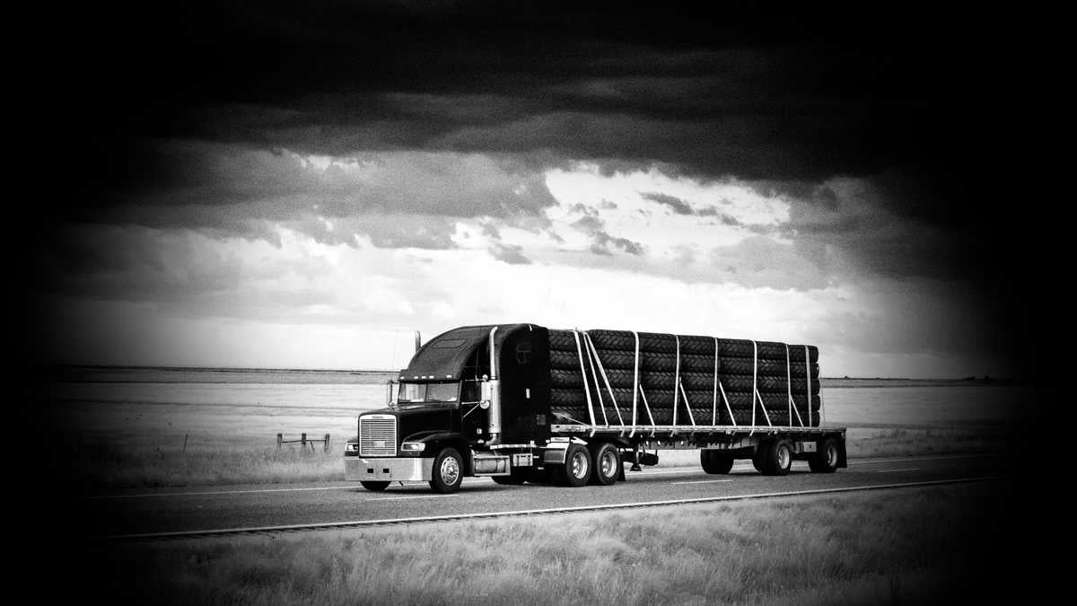 A tractor-trailer hauling oversized tires to illustrate an article about cargo theft.