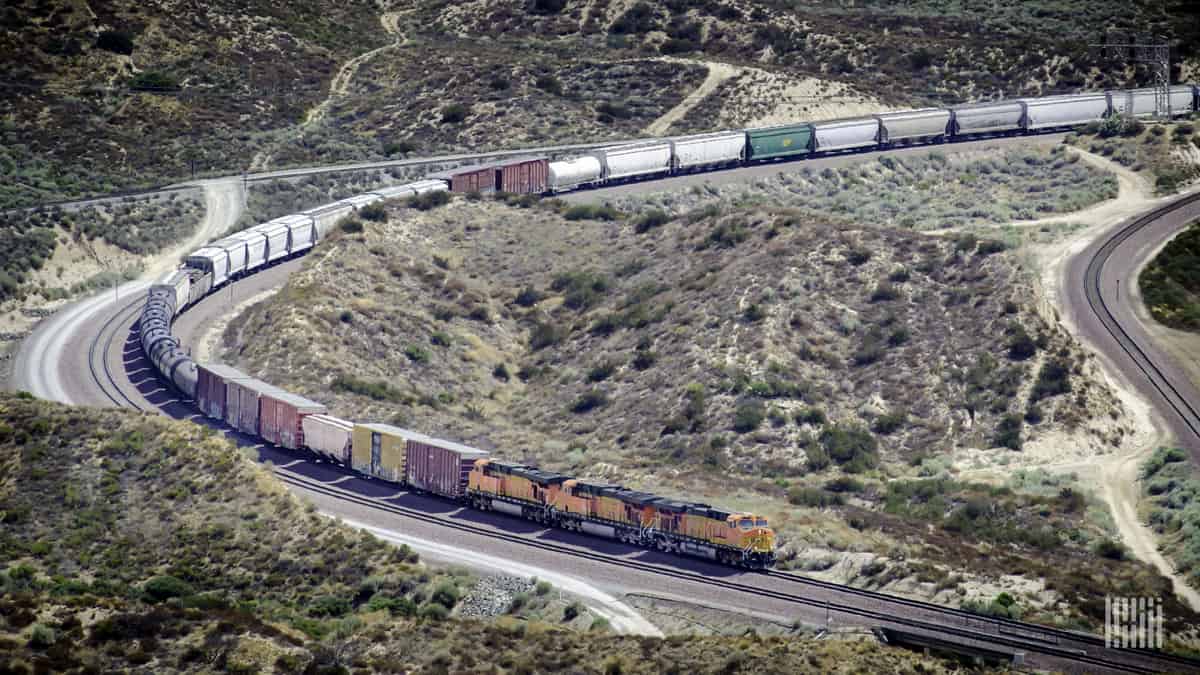 A photograph of a Union Pacific train weaving through a valley.