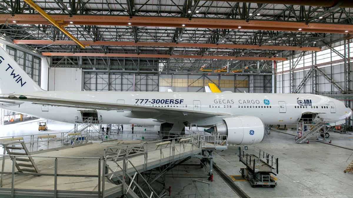 A large white plane in a hangar.