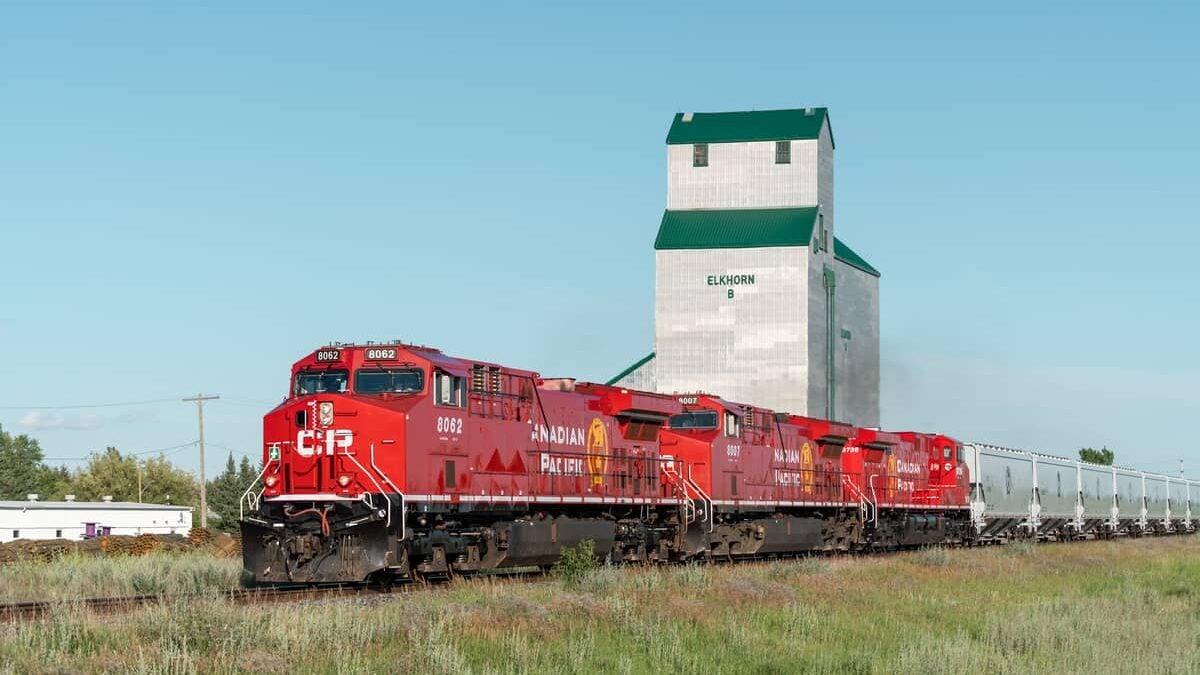 A photograph of a Canadian Pacific train in front of a grain elevator.