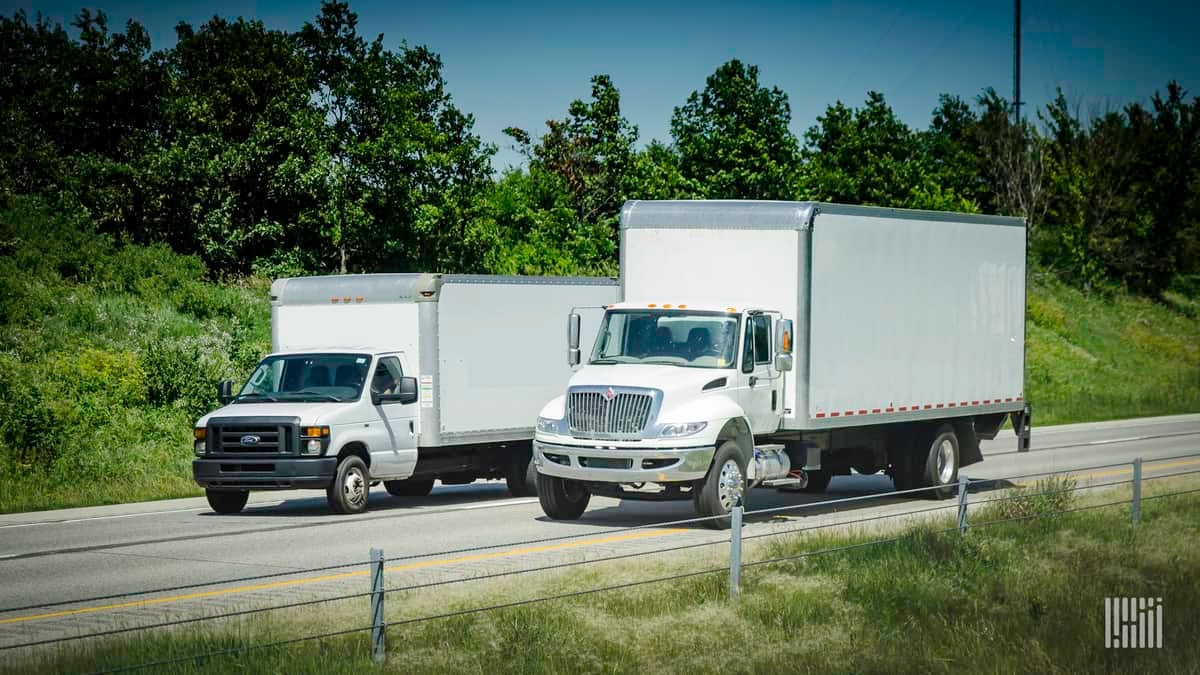 Two expedited delivery trucks on highway