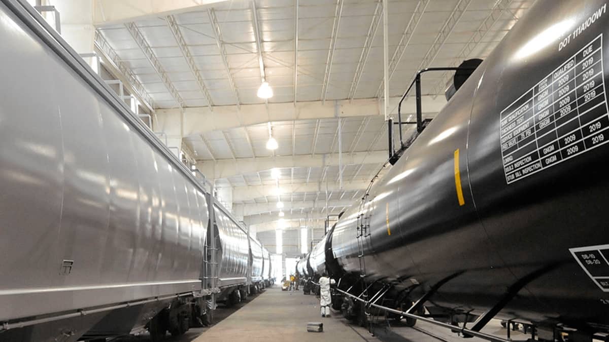 A photograph of two parked tank cars inside a building.