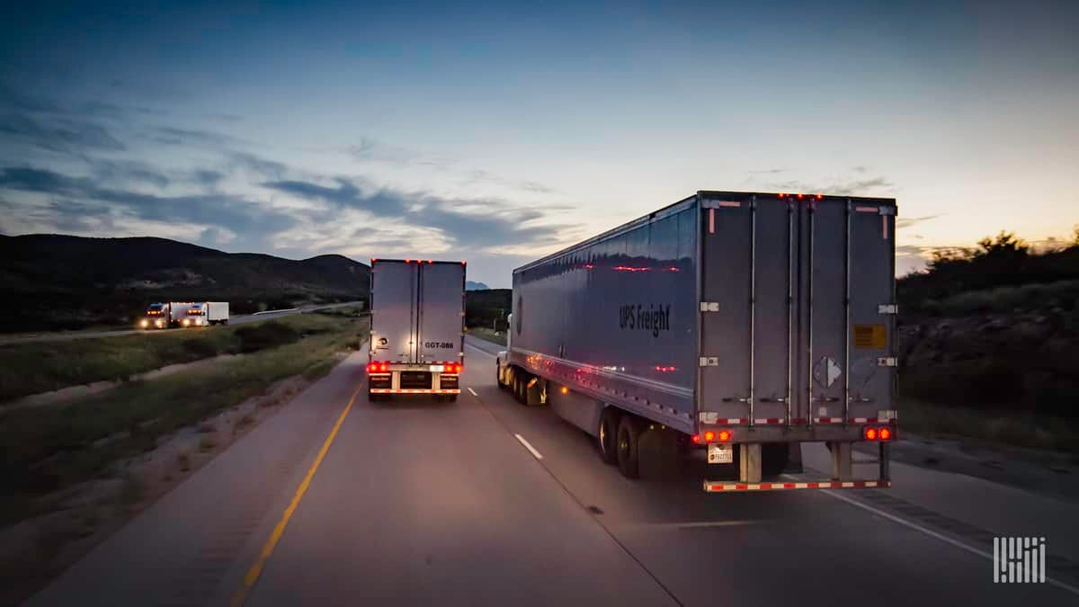 Two tractor-trailers from UPS Freight on the highway. TFI has closed its acquisition of UPS Freight.