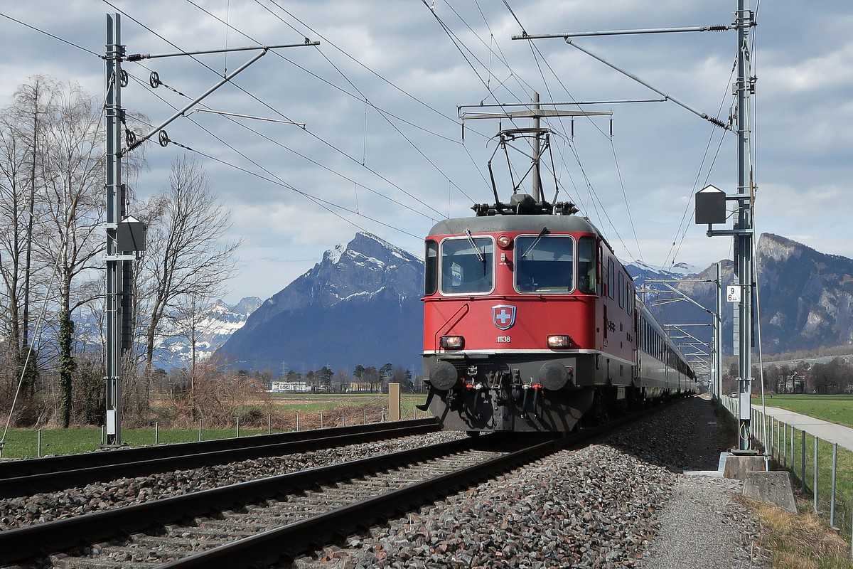 A photograph of a train on a track. The train is connected to catenaries.