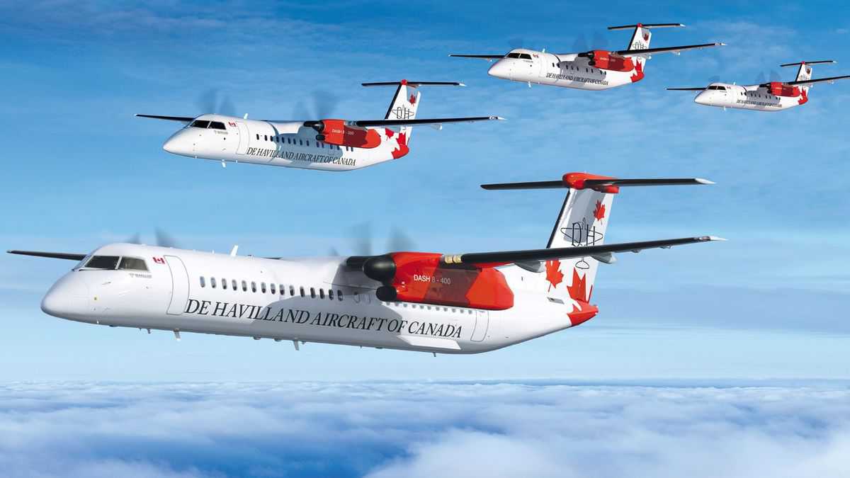 Four De Havilland turboprops fly in formation across blue sky with light clouds.