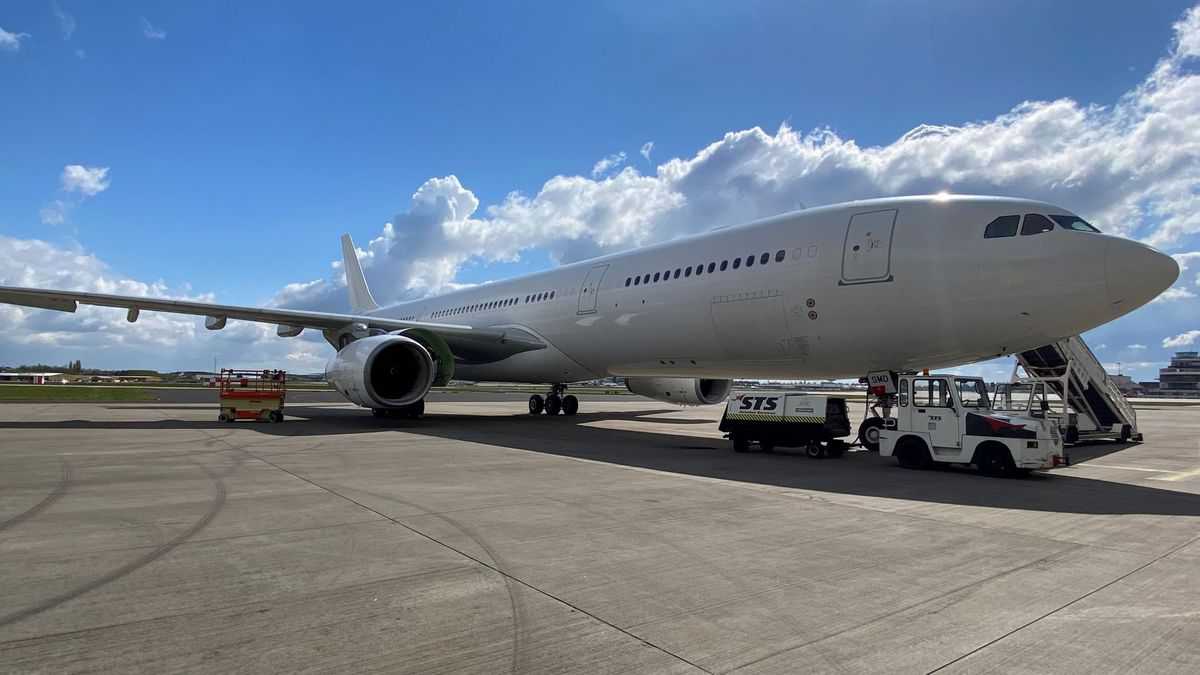 A large white jet with no logo on it, viewed from close at 45-degree angle on bright day.