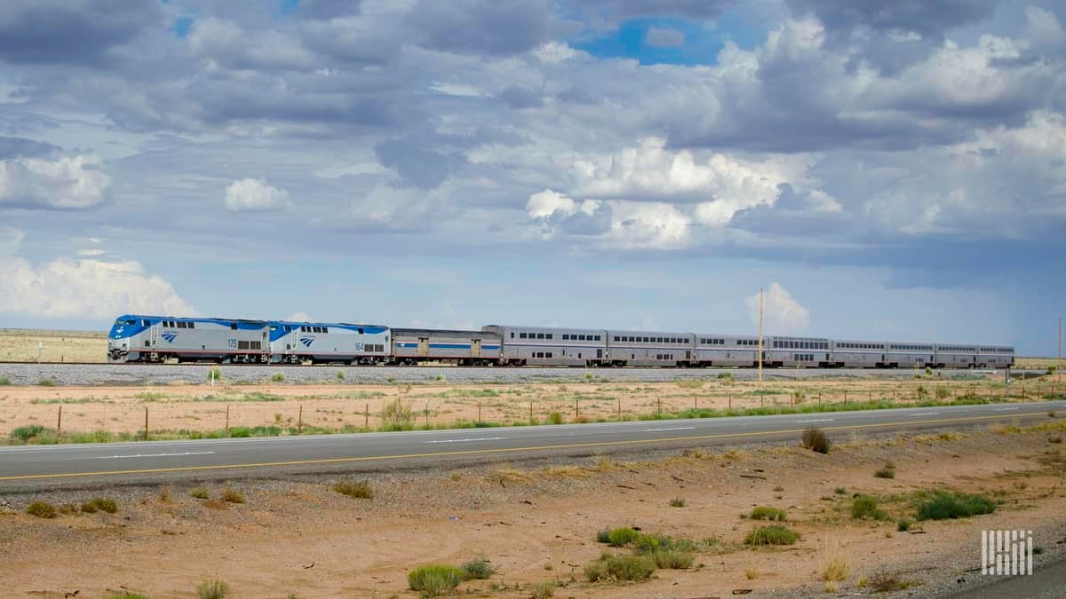 A photograph of an Amtrak train rolling down a desert field.