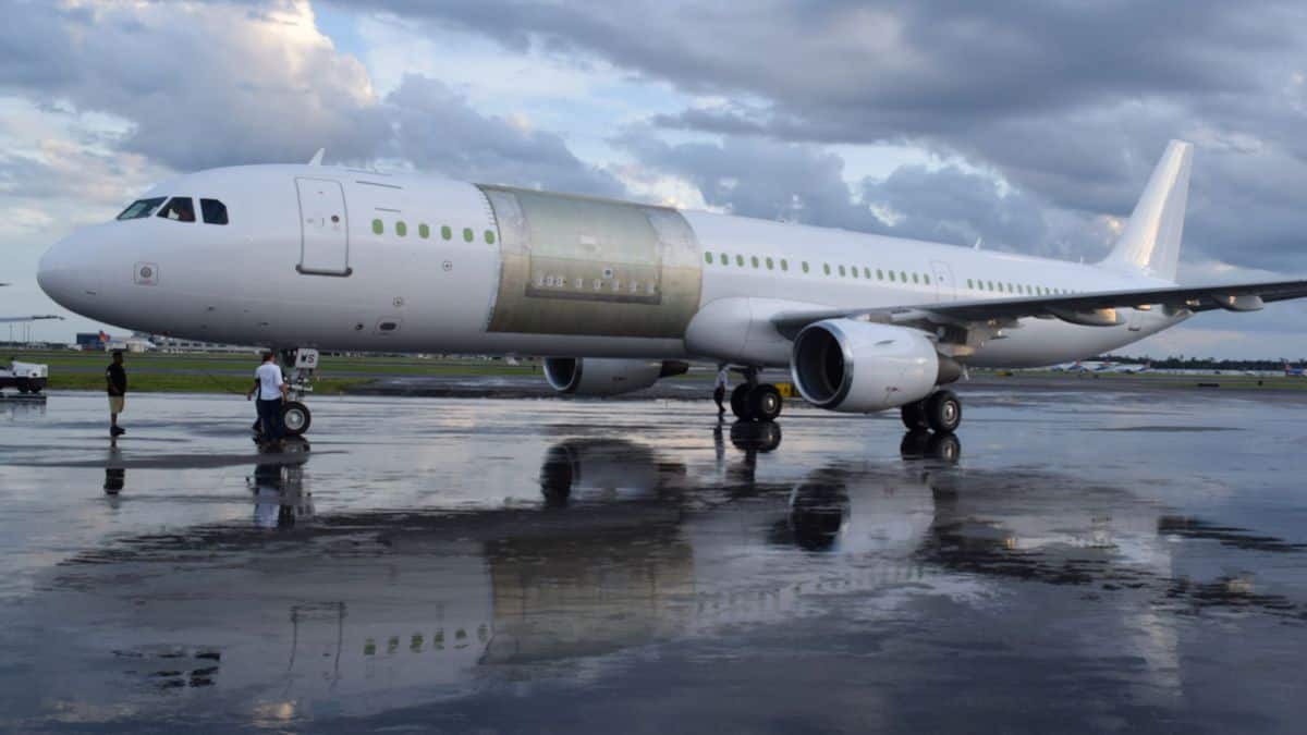 A white plane with a new cargo door installed as part of conversion to a freighter.