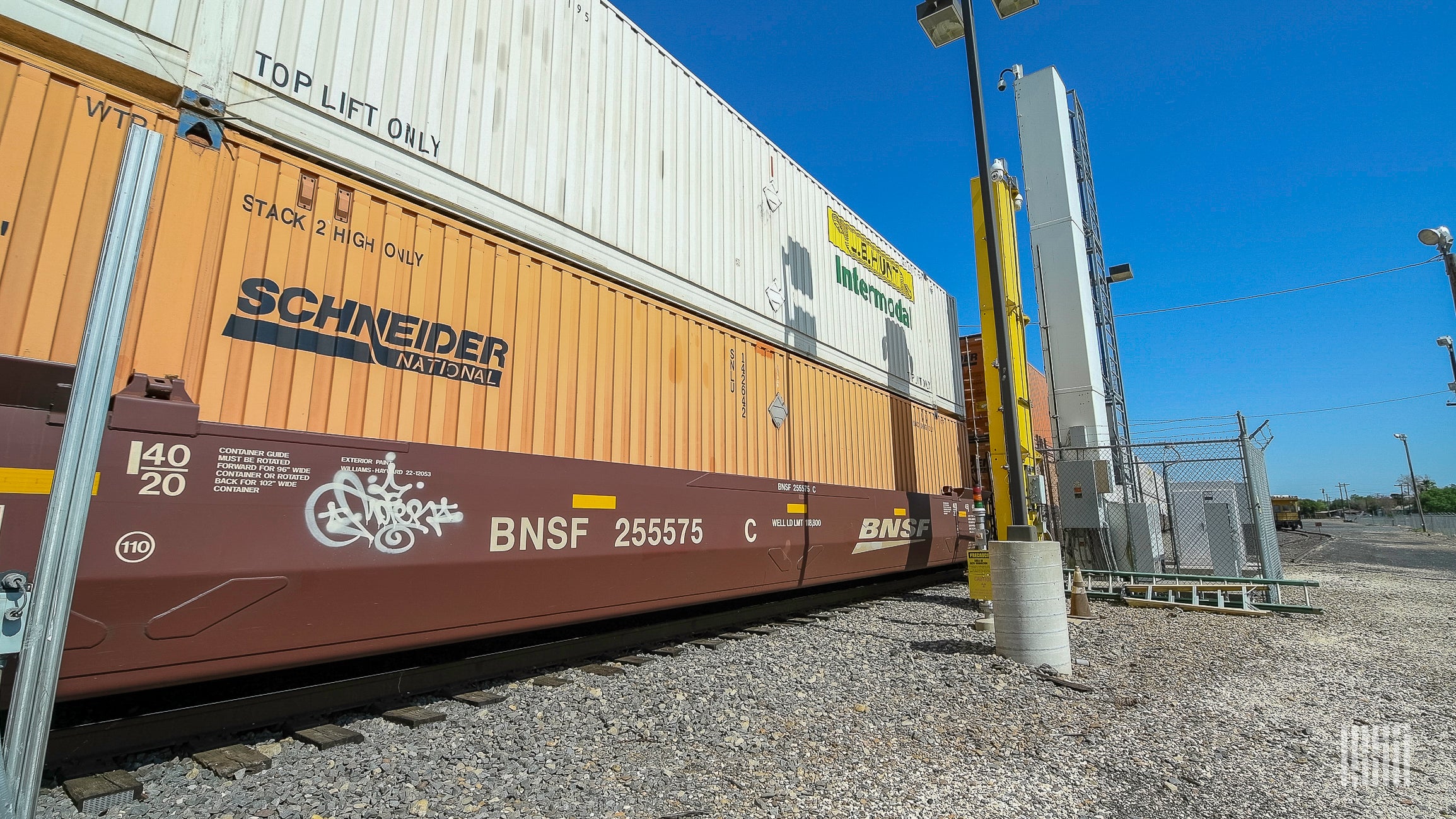 A photograph of intermodal containers stacked on a freight train.