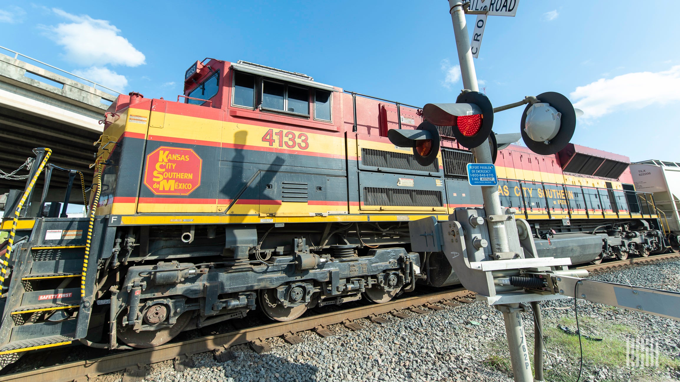 A photograph of a Kansas City Southern train at a rail crossing.