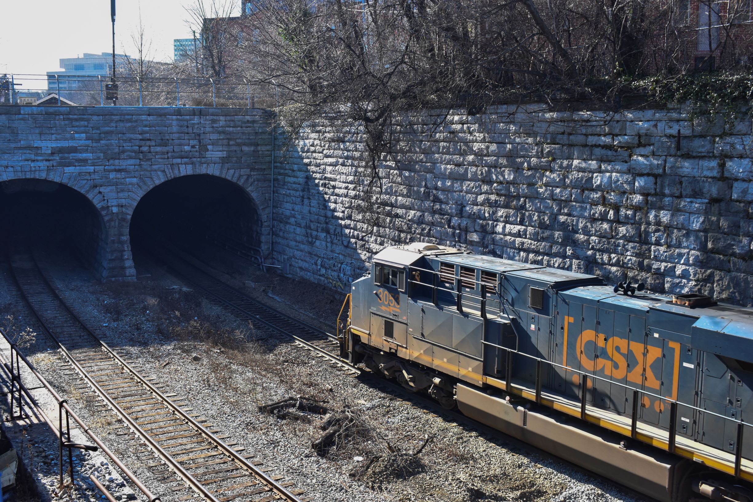 A photograph of a CSX train heading into a tunnel.