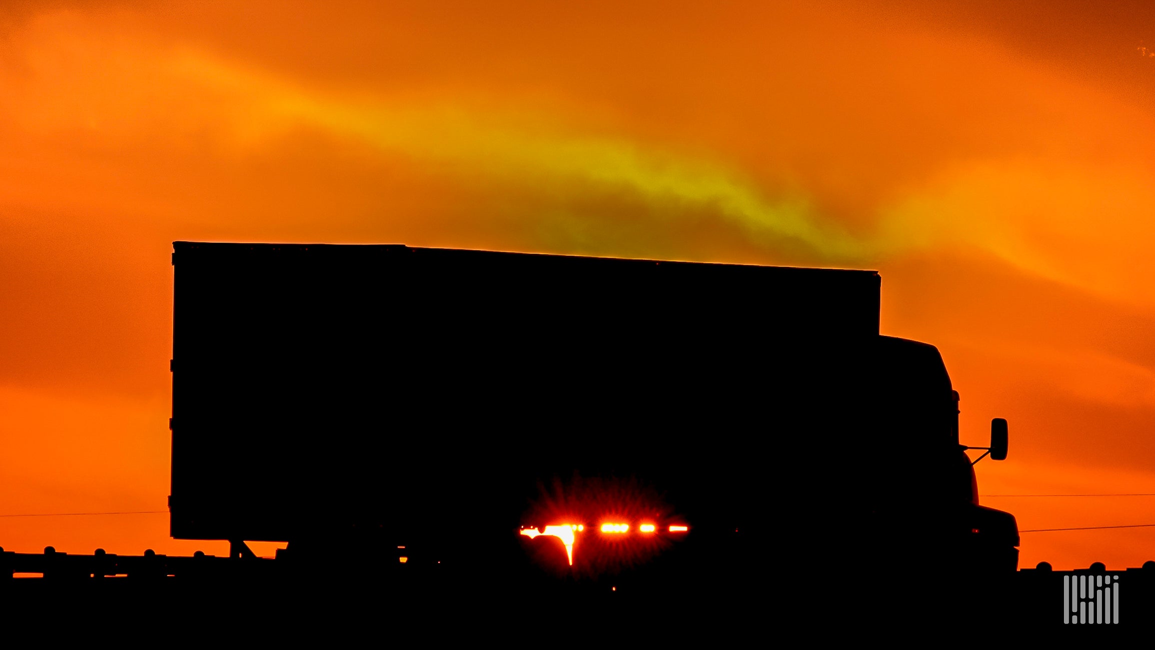 Tractor-trailer with "fiery" sun on the horizon