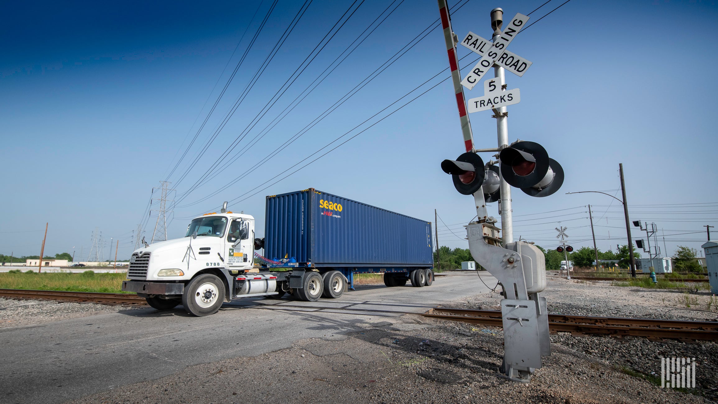 Tractor-trailer going through a railroad crossing.