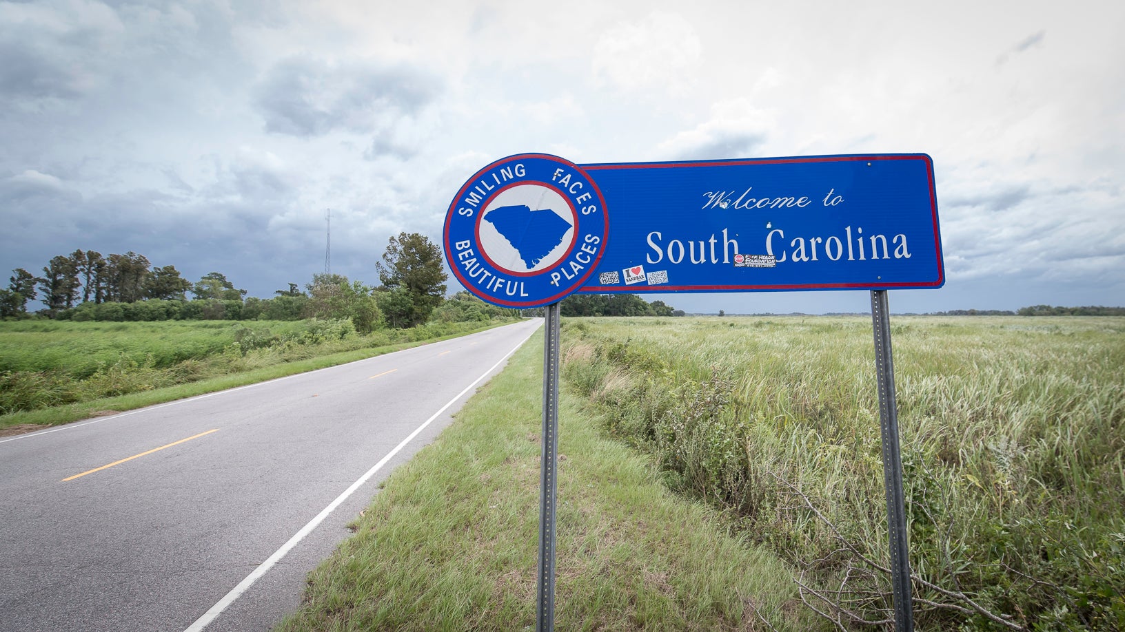 A photograph of a byway sign in the countryside. The sign is next to a road and the sign says Welcome to South Carolina.