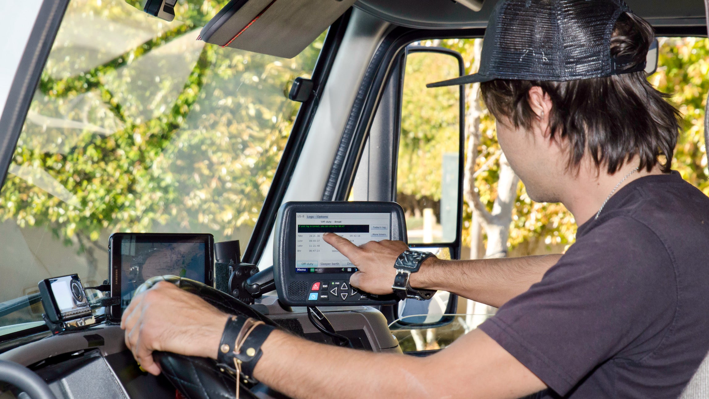 A view from inside the cab of a truck where a driver is using an ELD or electronic logging device, which whose use is required in Canada as of June 12.