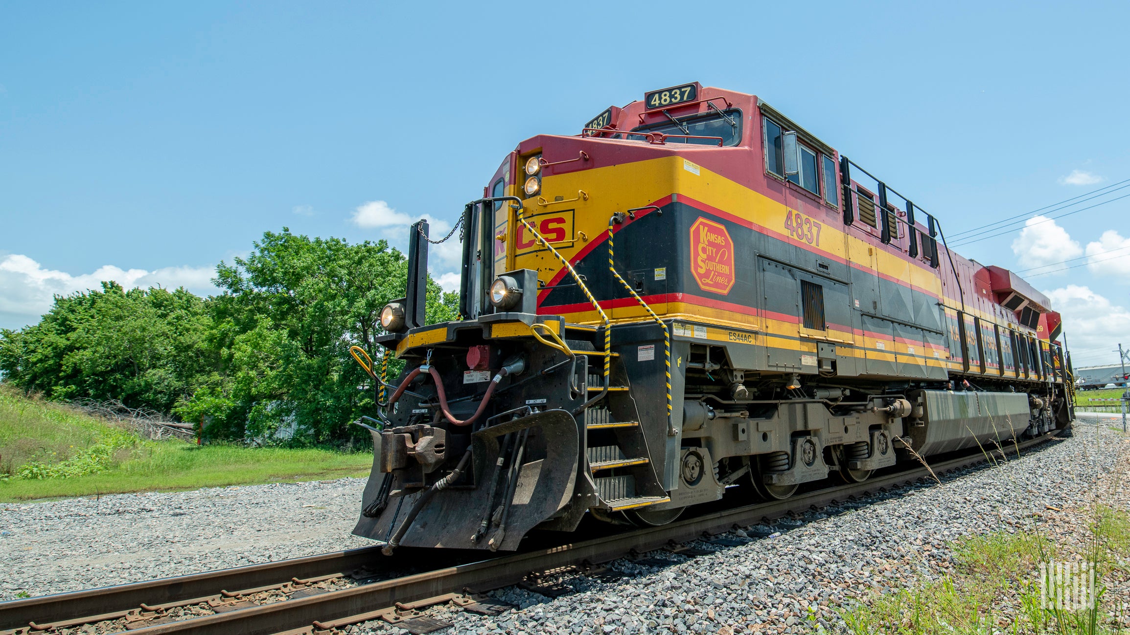 A photograph of a Kansas City Southern locomotive rolling down a train track.