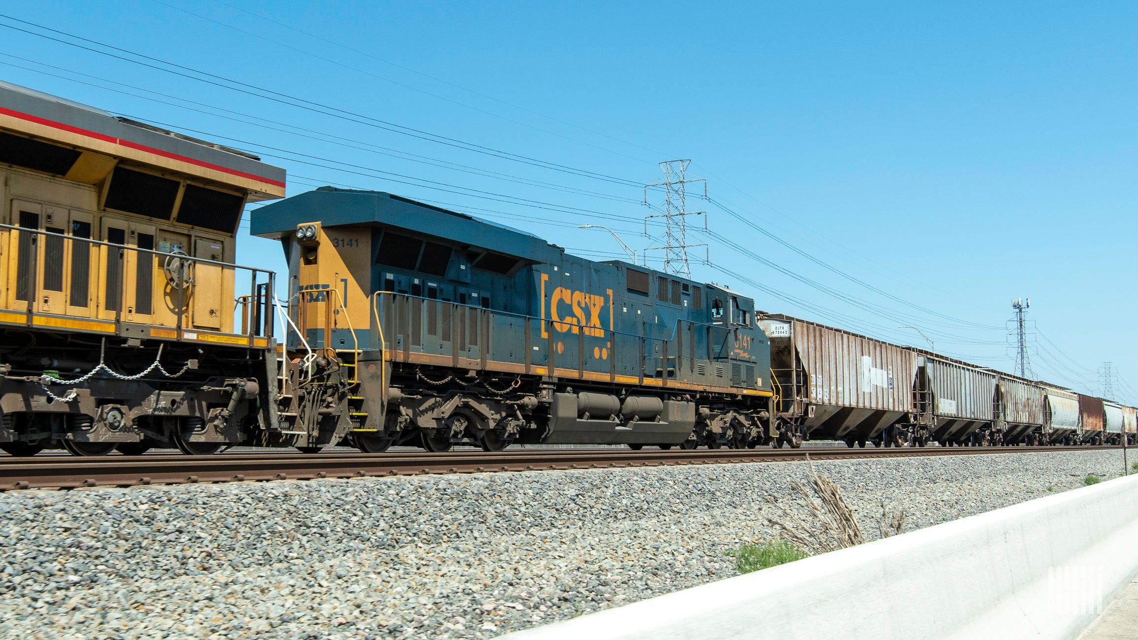 A photograph of a CSX train at a rail yard.