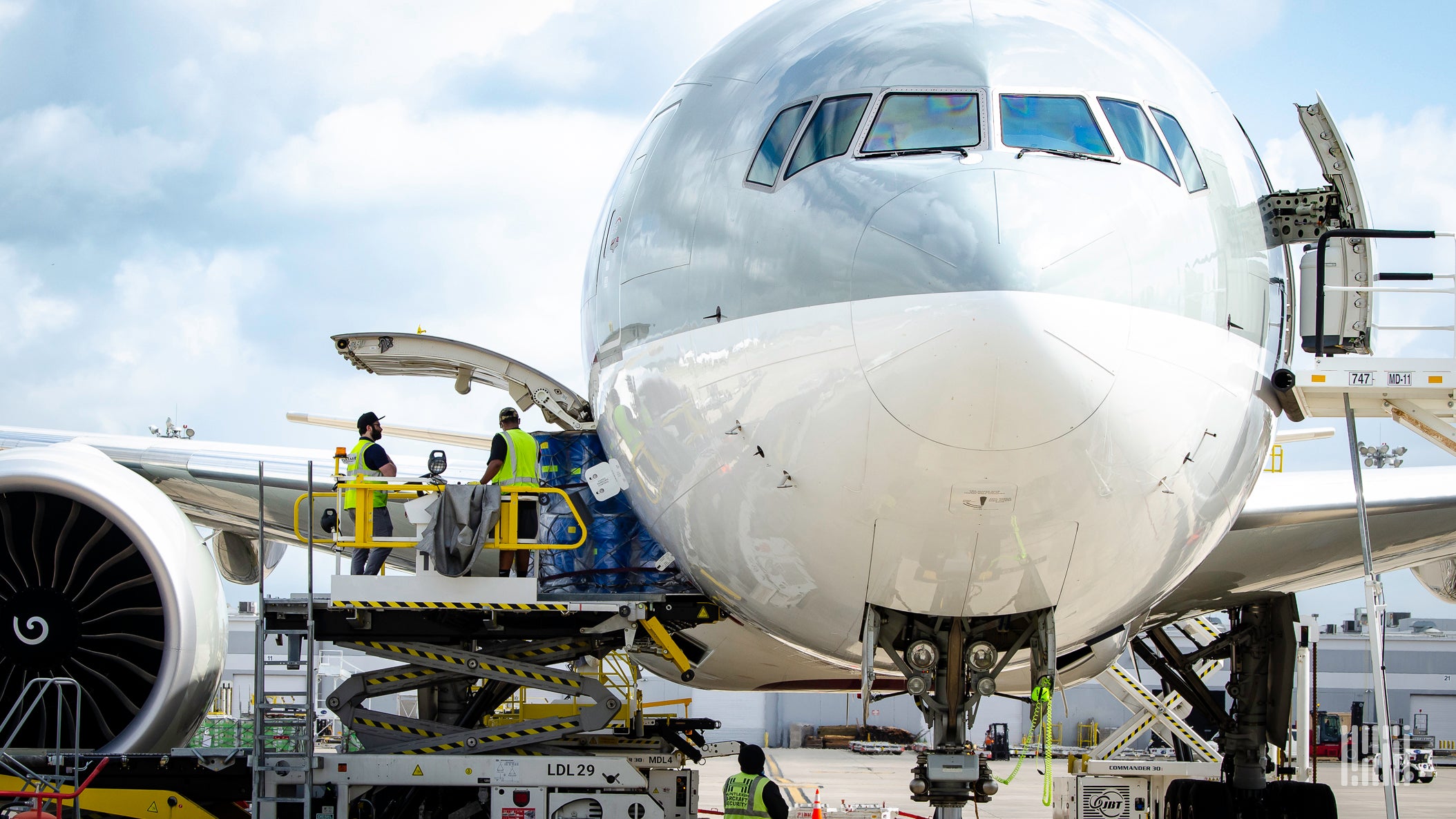 Crew loading/unloading cargo onto a jet.