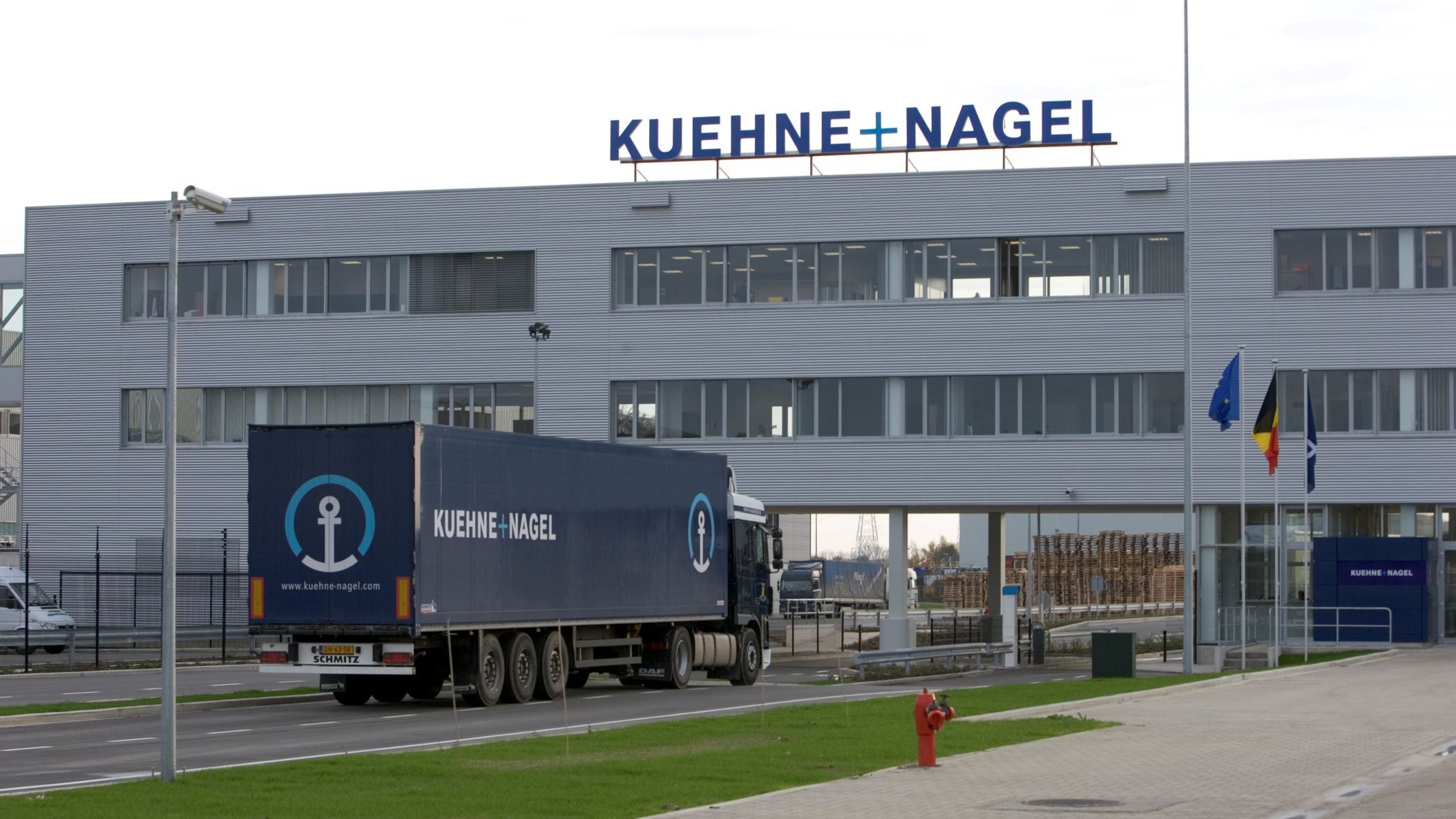 A Kuehne + Nagel truck approaches a K + N warehouse.