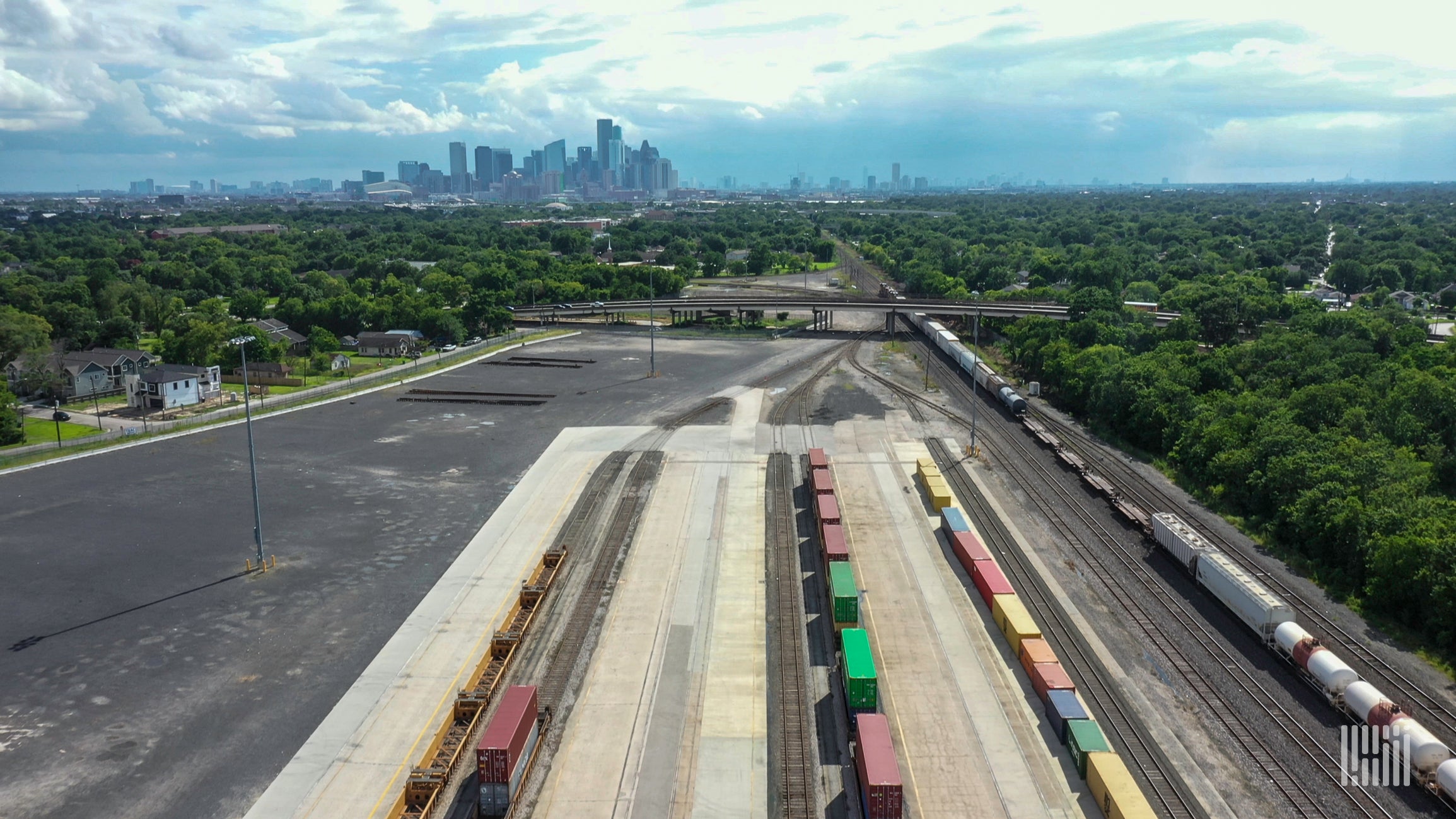 A photograph of a rail yard with a city in the distance.