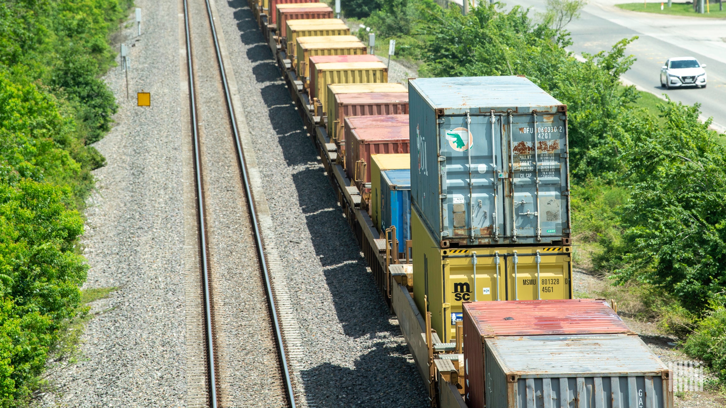 A photograph of intermodal containers being hauled by a freight train.