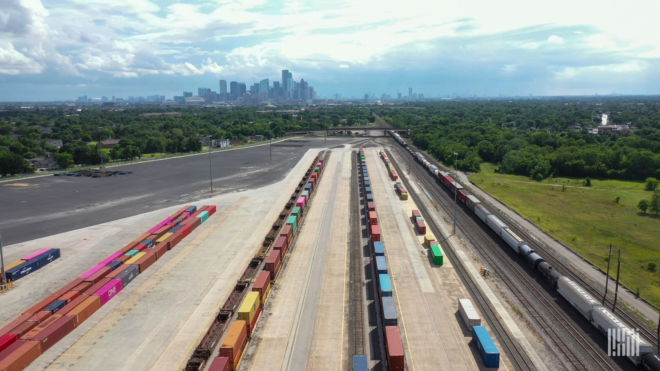 An aerial photograph of a rail yard with parked intermodal containers lined up in rows.