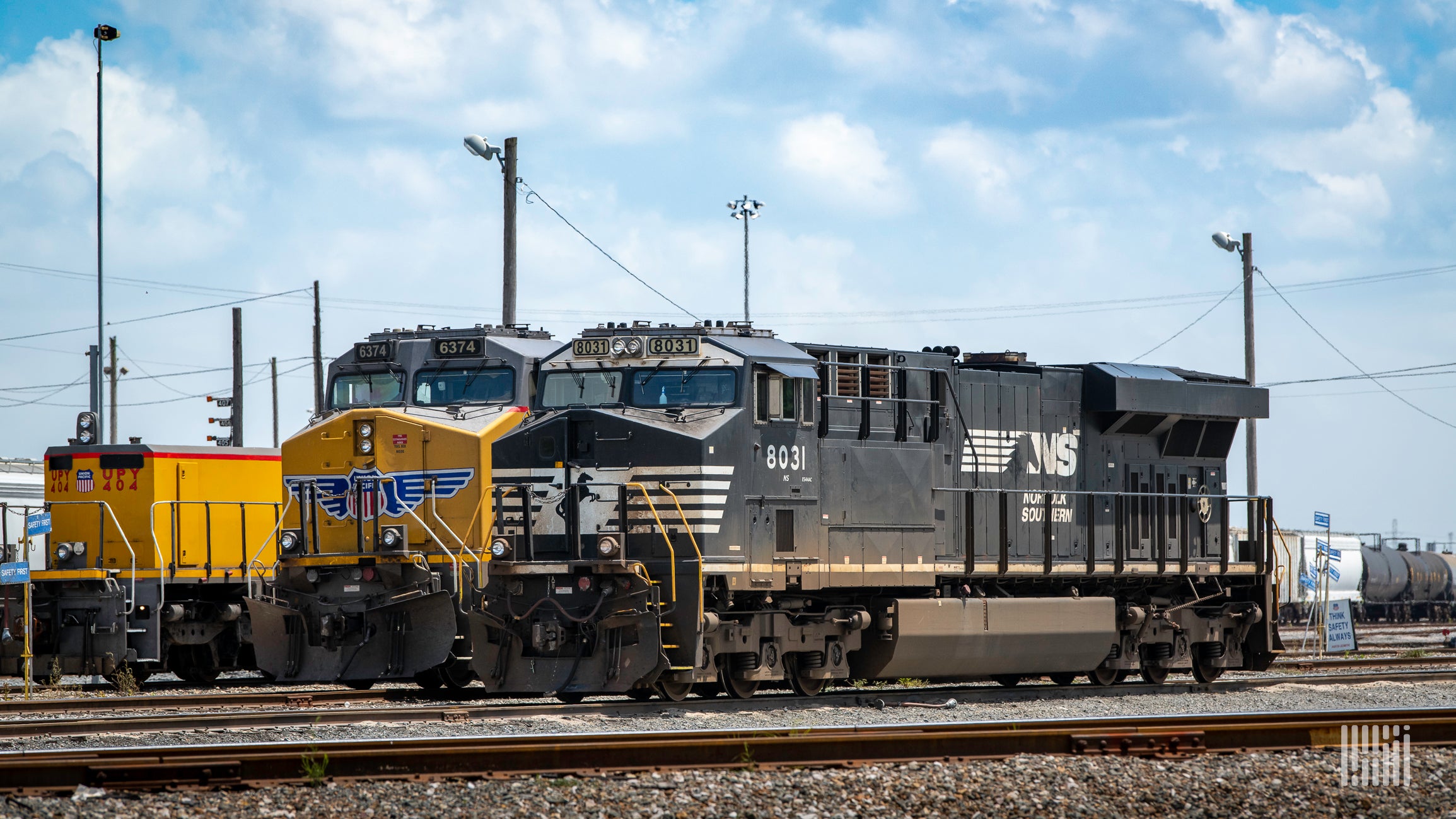 A photograph of a Norfolk Southern locomotive in front of a Union Pacific locomotive.