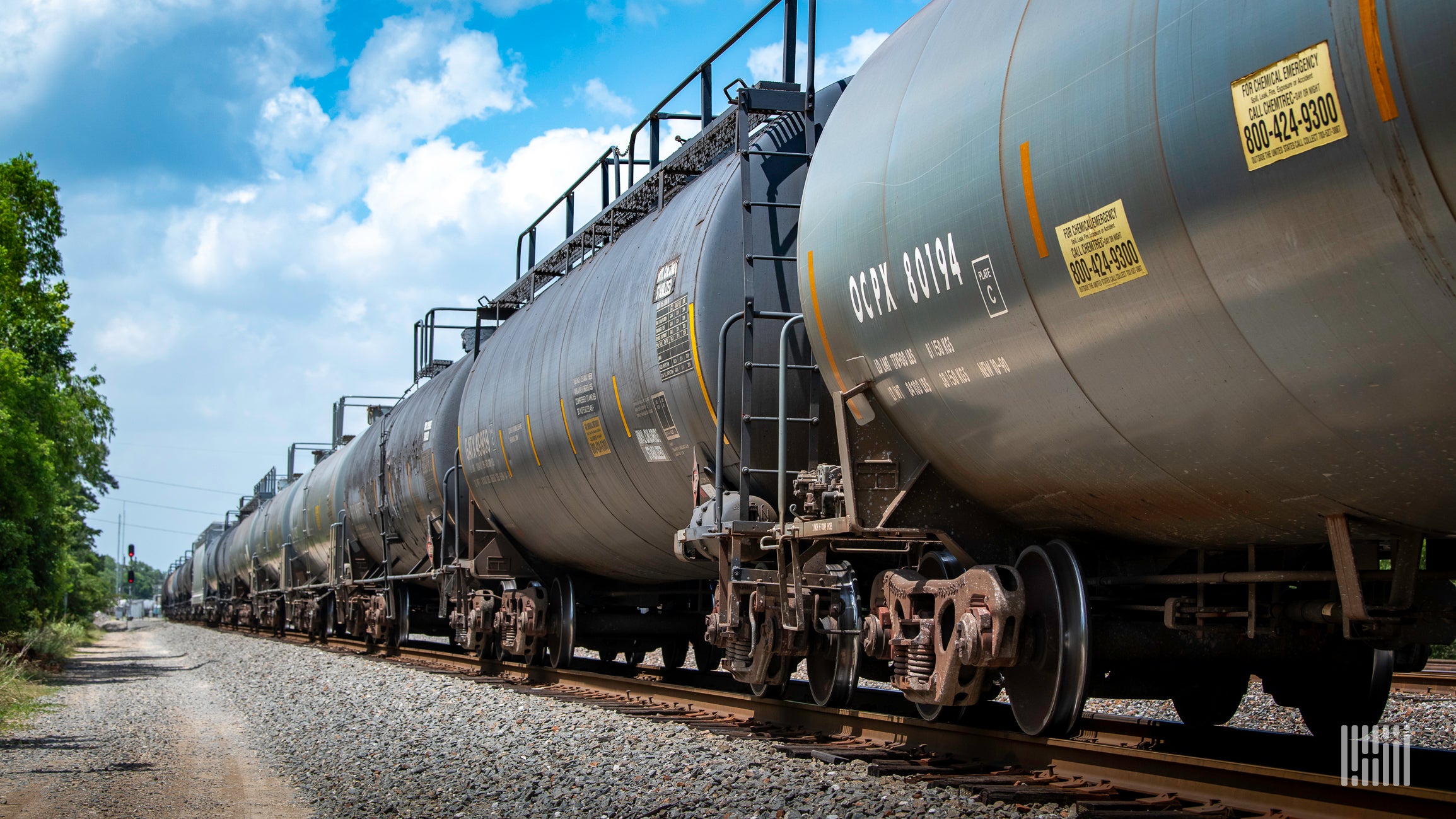 A photograph of tank cars parked in a rail yard.