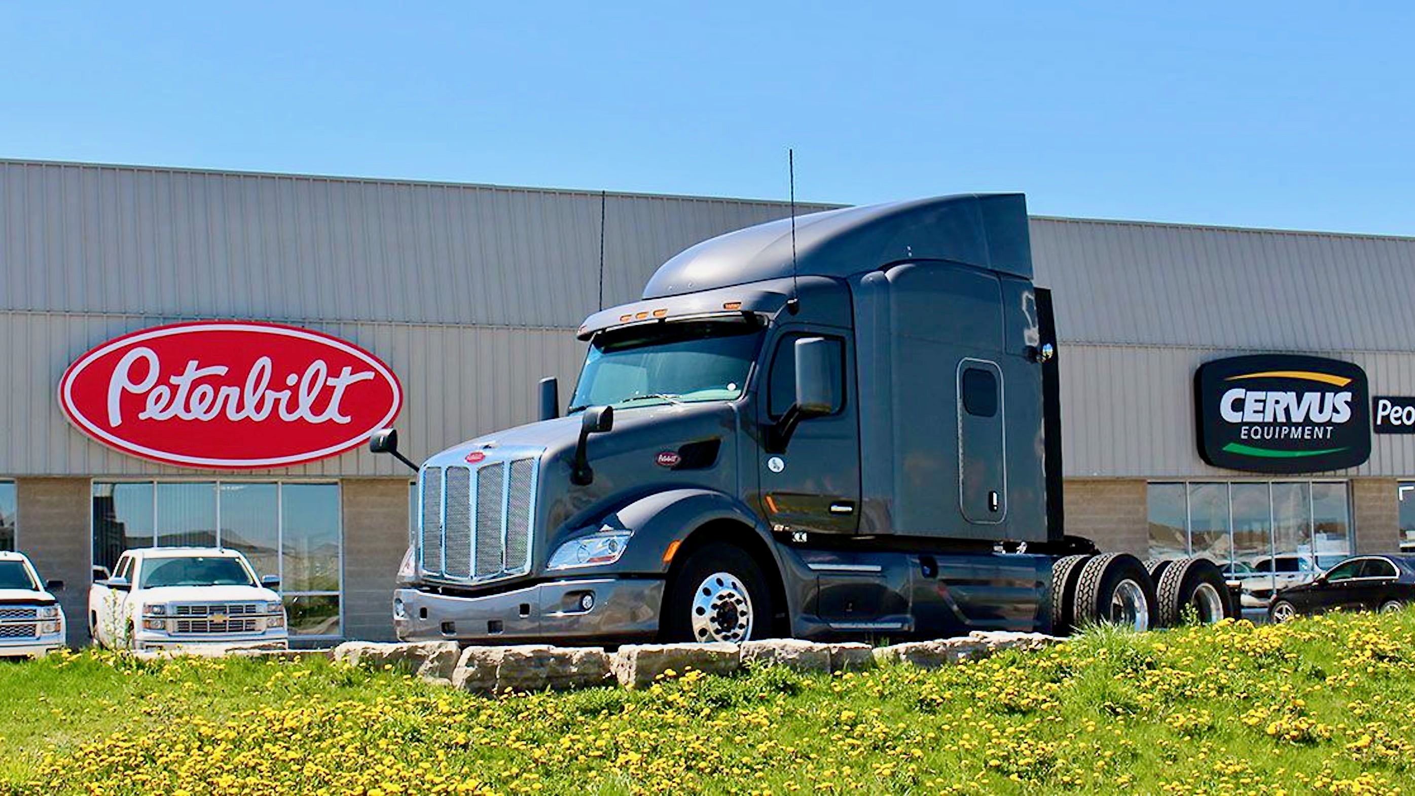 A truck between the logos of Peterbilt and Cervus Equipment.