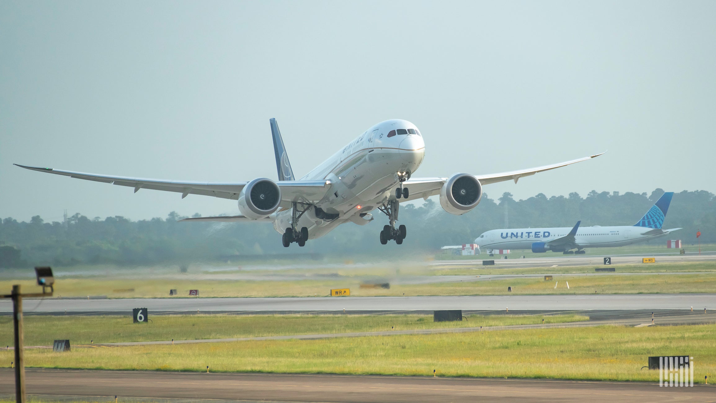 Front view of a plane taking off, with a United Airlines plane in the background.