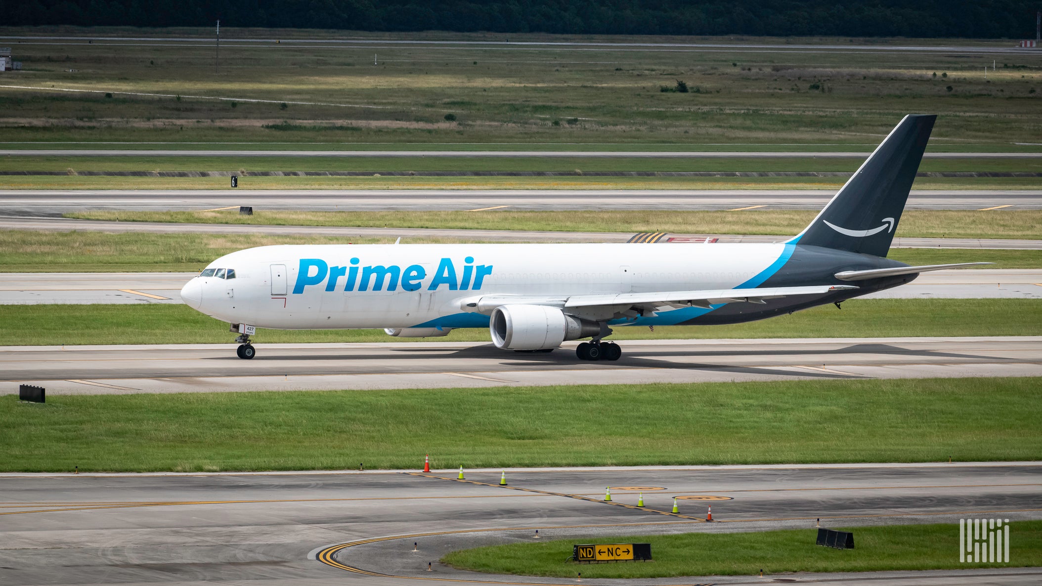 An Amazon Air jet, white with blue tail, on the runway.