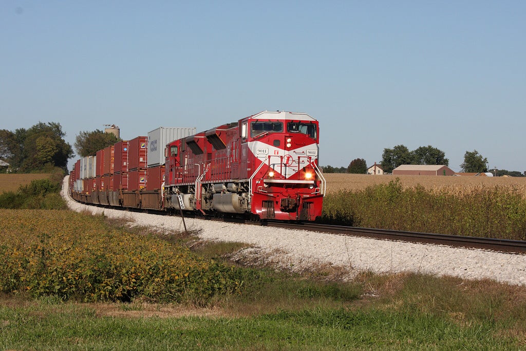 A photograph of a train rolling through a grassy field.