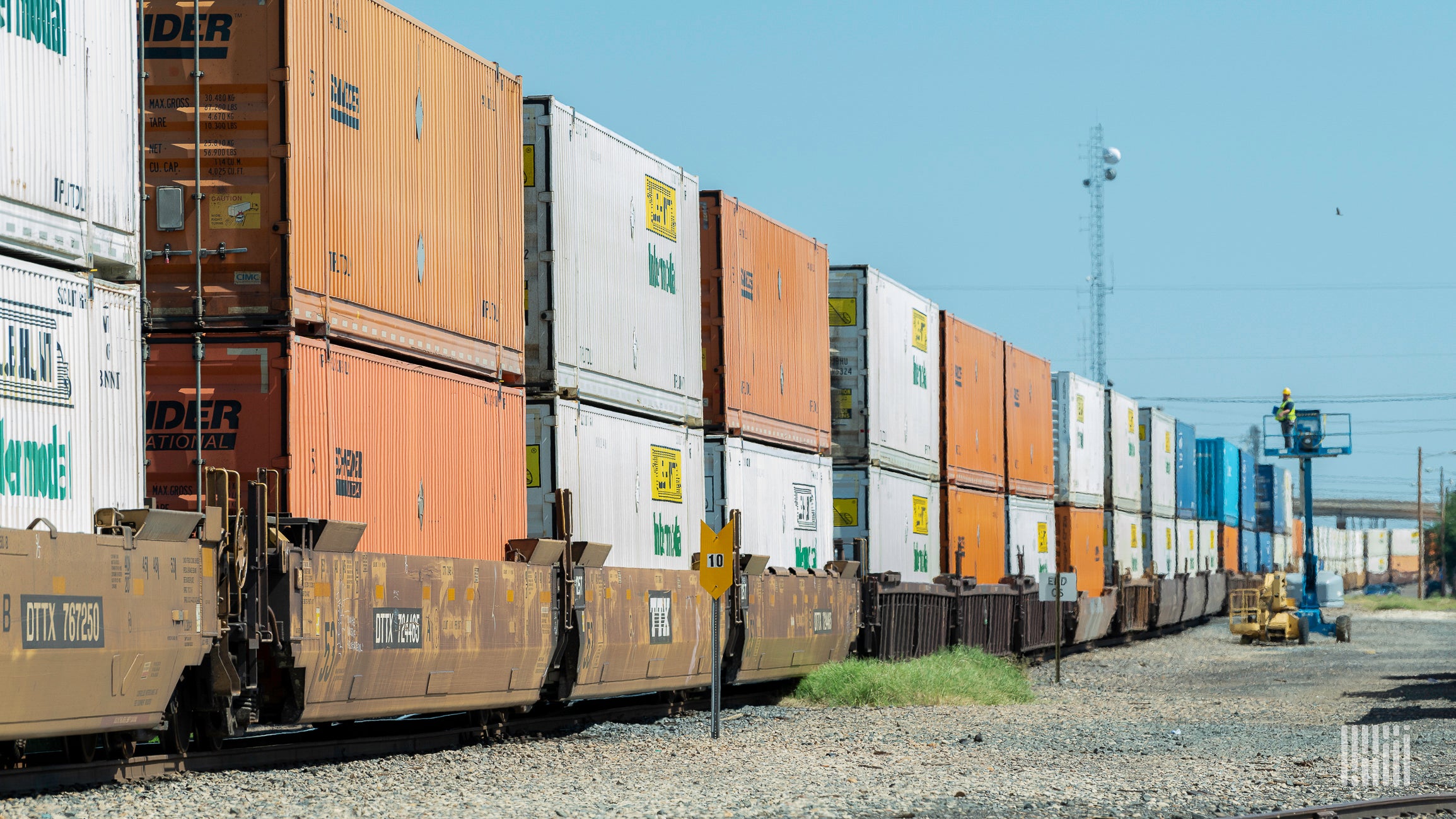 A photograph of a train hauling double-stacked intermodal containers.