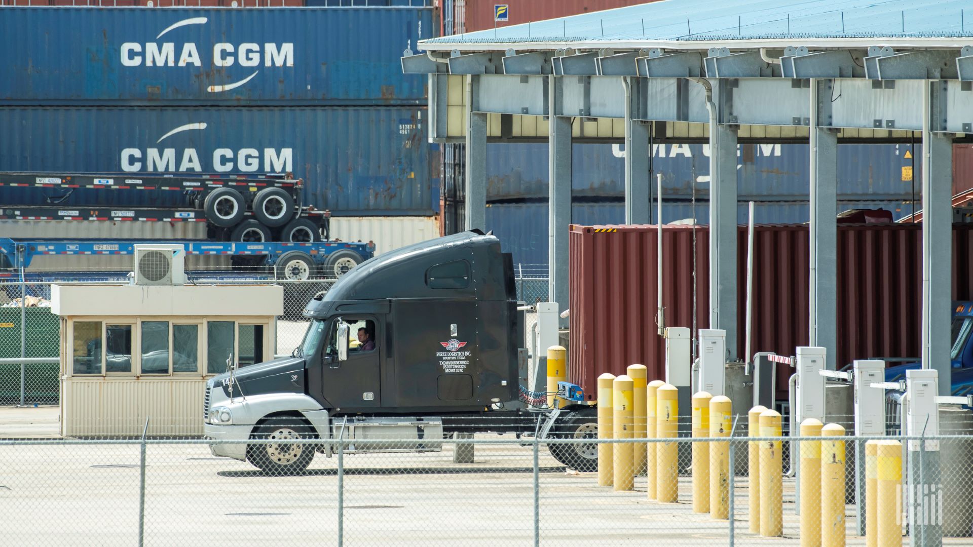 Trucks moving containers through port gates.