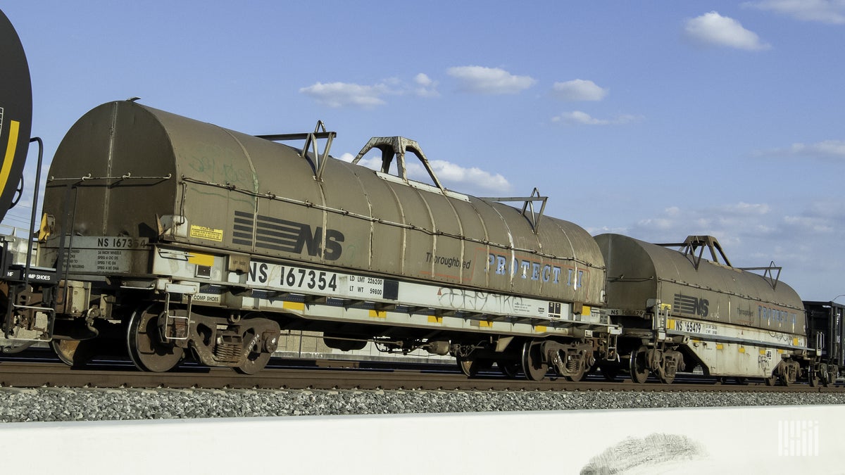 A photograph of tank cars with the letters NS painted on the side of the tank cars.